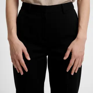 A person standing with both hands visible at their sides, fi