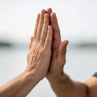 Two people doing a high-five, palms meeting with all fingers