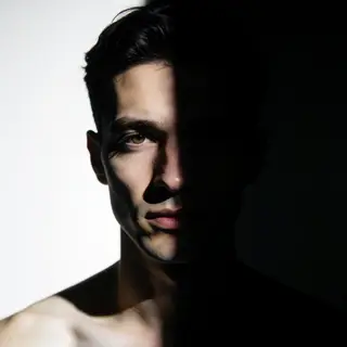 A portrait with dramatic split lighting — half the face brig