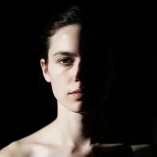 A portrait with dramatic split lighting — half the face brig