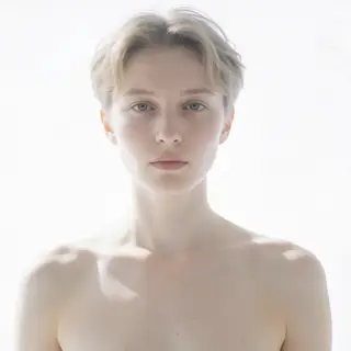 A high-key portrait of a person against a bright white backg