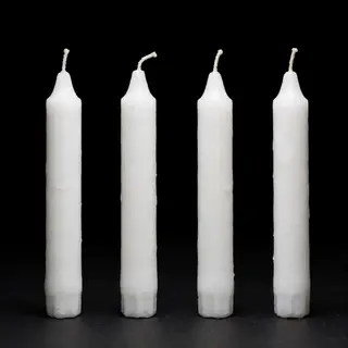 Exactly 4 white candles standing on a dark surface