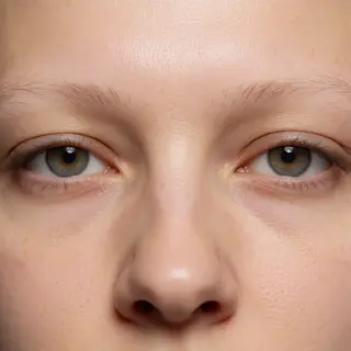 A human face with eyes, nose, and mouth but no eyebrows