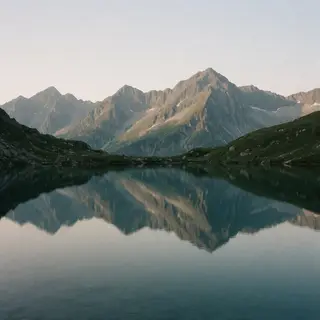 A mountain range reflected in a still alpine lake, with the 