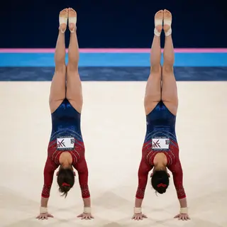 Two gymnasts performing a synchronized handstand, side by si