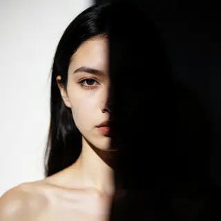 A portrait with dramatic split lighting — half the face brig