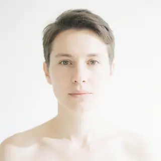 A high-key portrait of a person against a bright white backg
