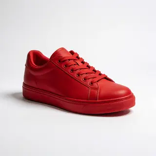 A single red sneaker on a clean white background with soft s