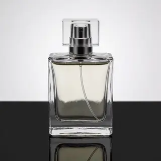 A clear glass perfume bottle on a reflective black surface w