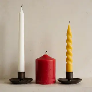 A tall thin white candle, a short fat red candle, and a medi
