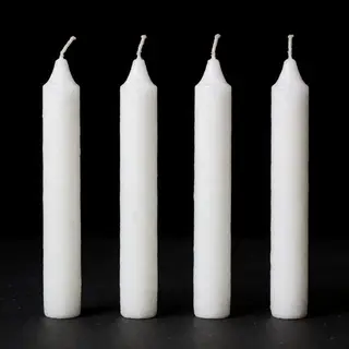 Exactly 4 white candles standing on a dark surface
