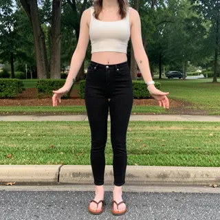 A person standing in a neutral pose in a park, full body vis