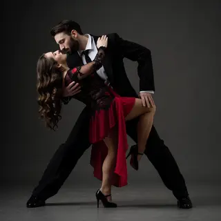 Two tango dancers in a close embrace, the man dipping the wo