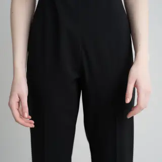 A person standing with both hands visible at their sides, fi