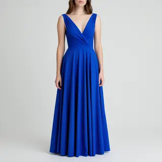 A woman wearing a royal blue evening dress against a neutral