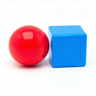 A red ball and a blue cube sitting side by side on a white s