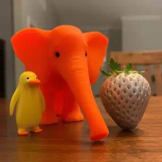 An orange elephant, a yellow penguin, and a silver strawberr