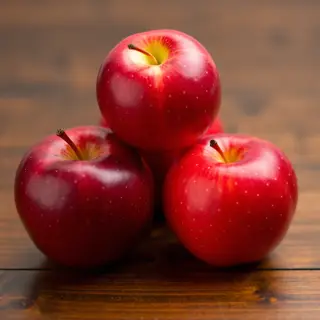 Exactly 3 red apples arranged on a wooden table