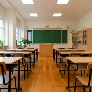 A classroom with desks and a chalkboard but no students