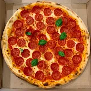 A pepperoni pizza with tomato sauce, basil, and crust but ab
