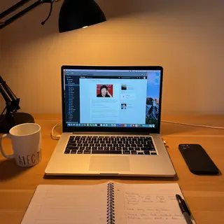 A desk scene: laptop in the center, coffee mug to the left, 