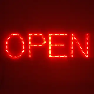 The word 'OPEN' displayed on a red LED sign with glowing pix