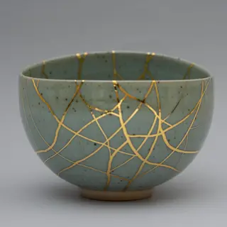 A Japanese kintsugi bowl — cracked ceramic repaired with vis