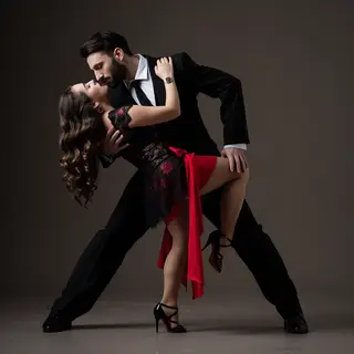 Two tango dancers in a close embrace, the man dipping the wo