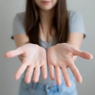 A woman holding her hands out in front of her palms-up, all 