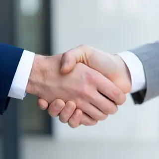 Two people shaking hands in a professional setting, all fing