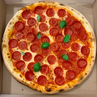 A pepperoni pizza with tomato sauce, basil, and crust but ab