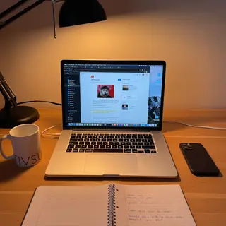 A desk scene: laptop in the center, coffee mug to the left, 