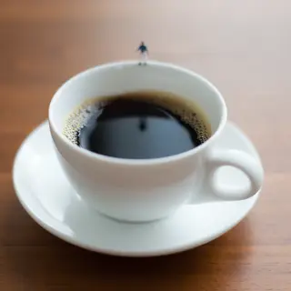 A tiny person standing on the rim of a coffee cup, looking d