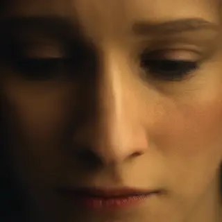 A face showing quiet melancholy — downcast eyes, slightly dr