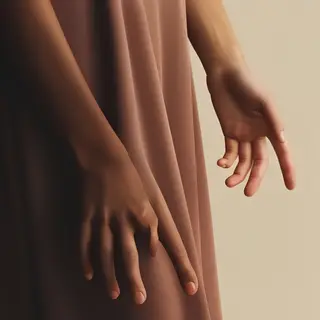 A person standing with both hands visible at their sides, fi