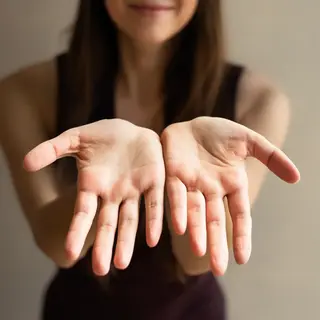 A woman holding her hands out in front of her palms-up, all 