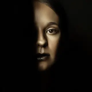 A portrait with dramatic split lighting — half the face brig
