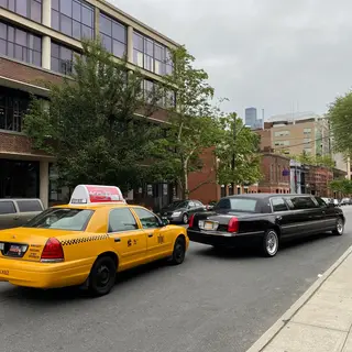 A yellow taxi and a black limousine parked next to each othe