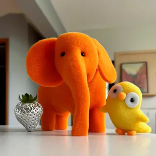 An orange elephant, a yellow penguin, and a silver strawberr