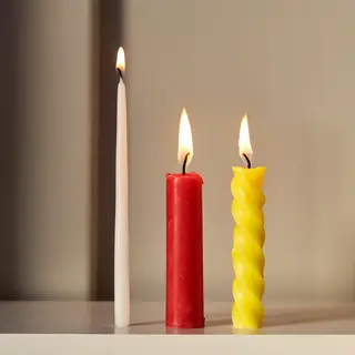 A tall thin white candle, a short fat red candle, and a medi