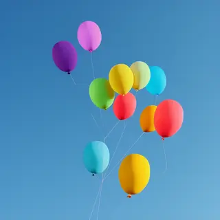 Exactly 11 colorful balloons floating against a clear blue s