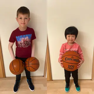 A child holding a basketball, both at correct relative sizes