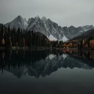 A mountain range reflected in a still alpine lake, with the 