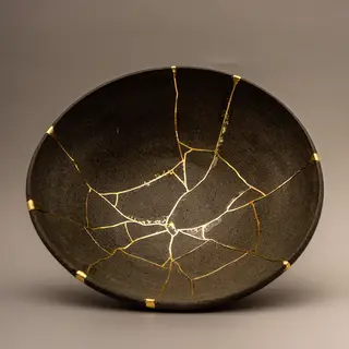 A Japanese kintsugi bowl — cracked ceramic repaired with vis
