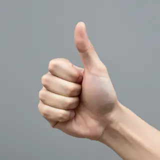 A hand giving a thumbs-up with four fingers curled and thumb