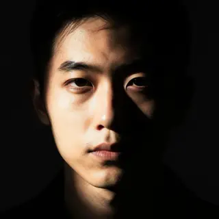 A portrait with dramatic split lighting — half the face brig