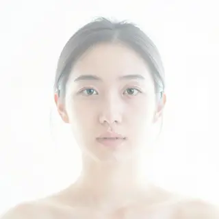 A high-key portrait of a person against a bright white backg