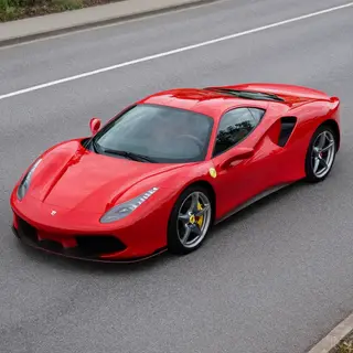 A bright red sports car parked on a gray asphalt road — the 