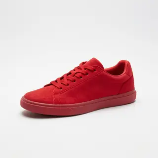A single red sneaker on a clean white background with soft s