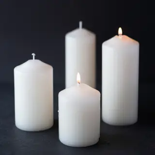 Exactly 4 white candles standing on a dark surface
